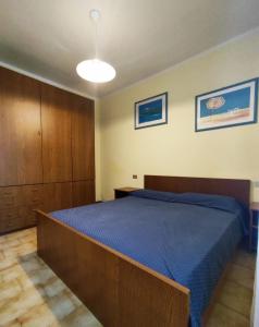 ein Schlafzimmer mit einem großen Bett mit einer blauen Decke in der Unterkunft Ambra in Bibione
