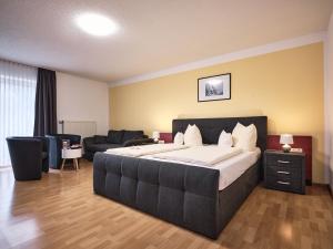 a bedroom with a large bed and a couch at TIPTOP Hotel am Hochrhein in Bad Säckingen