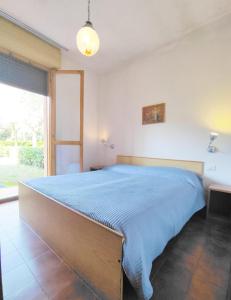 1 dormitorio con 1 cama grande con manta azul en Villaggio White Star, en Bibione
