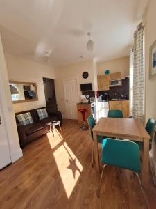 a kitchen and living room with a table and chairs at Hebridean Town House in Stornoway