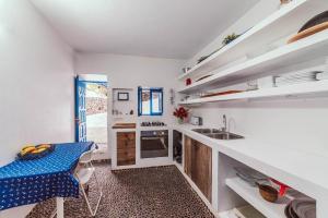a kitchen with white walls and a table and a sink at Seaside Villa La Graciosa in Pedro Barba