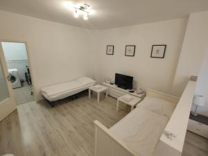 a white room with a bed and a tv at Antonio Appartement in Steinabrückl