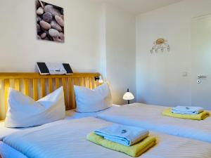 2 Betten in einem Zimmer mit Handtüchern darauf in der Unterkunft Haus Inge in Heringsdorf