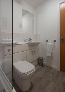 a white bathroom with a toilet and a sink at Parkhill Luxury Serviced Apartments - Hilton Campus in Aberdeen