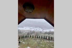 a view of a snow covered mountain through a window at Albanian traditional Villa in Librazhd