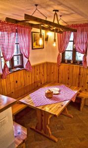een eetkamer met een tafel en rode en witte geruite gordijnen bij Vineyard cottage Podržaj in Otočec