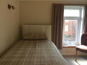 A bed or beds in a room at Blantyre Guest House 