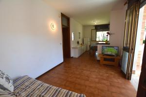 a living room with a couch and a tv in it at Lignano Pineta in Lignano Sabbiadoro