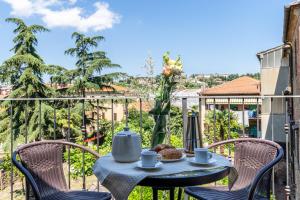 a table with a tea kettle and chairs on a balcony at La Piazza - Appartamento con vista in Sinalunga