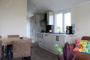 a kitchen with white cabinets and a counter top at Chalet Sky de luxe in Drijber