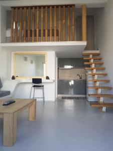 un salon avec un escalier et une table dans l'établissement Empyreal Blue Apartments, à Dexamenes