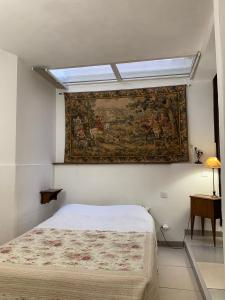 a bedroom with a painting on the wall and a bed at Maison Héloïse in Avignon