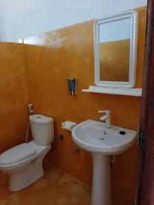 ein Badezimmer mit Toilette, Waschbecken und Spiegel in der Unterkunft Kendwa Carletto Style in Kendwa + 56 Fotos