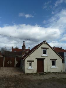 una pequeña casa blanca con una puerta roja en La Petite maison en Sologne, en Salbris