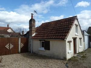 una pequeña casa blanca con techo marrón en La Petite maison en Sologne, en Salbris