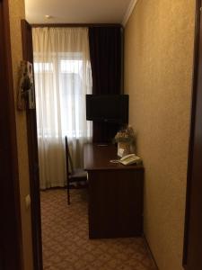 a hotel room with a desk with a television and a window at Hotel-Restaurant Lyube Plus in Khmelnytskyi