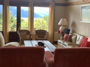 uma sala de estar com um sofá, uma mesa e cadeiras em Arelauquen Bungalows & Suites em San Carlos de Bariloche