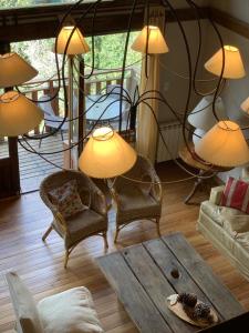 een woonkamer met stoelen en een tafel en lampen bij Arelauquen Bungalows & Suites in Bariloche