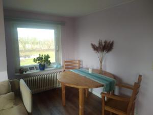 a dining room with a table and a window at Ferienwohnung-Auszeit in Hürup +7 photos