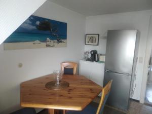 a kitchen with a wooden table and a refrigerator at Ferienwohnung-Auszeit in Hürup