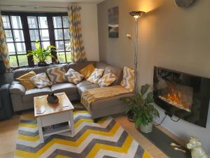 a living room with a couch and a fireplace at 20 Tudor Court " Four Star AA accommodation" in Hayle