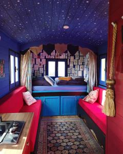 a train room with two beds and a kitchen at La roulotte MAGIC ! des Grillots in Beaulon