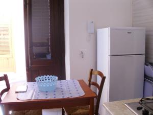 a kitchen with a table and a white refrigerator at Charming House in Castellammare del Golfo with Balcony in Castellammare del Golfo +24 photos