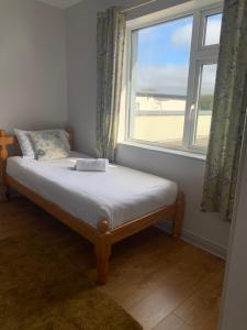 a bed in a room with a window at Newcastle Townhouse in Galway