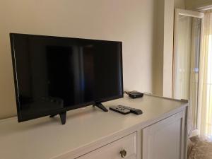 Departamentos Premium - 2 Ambientes - Excelente ubicación في ميرامار: تلفزيون بشاشة مسطحة موضوع فوق خزانة +صورة واحدة