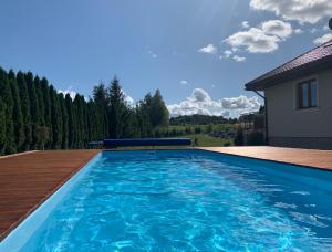 a swimming pool with blue water in a yard at Apartamenty Euphoria in Gołdap