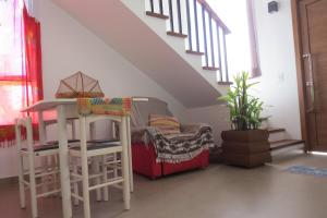 Zimmer mit zwei Hockern, einem Tisch und einer Treppe in der Unterkunft CASA NOVA CONFORTÁVEL E ACONCHEGANTE in Garopaba