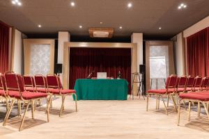 una sala de conferencias con sillas rojas y una mesa verde en Cristallo Club, en Aprica