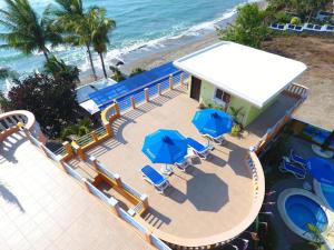 P&M Final Option Beach Resort في سان خوان: مسبح وكراسي ومظلات بجوار المحيط