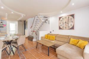 a living room with a couch and a clock on the wall at Aqua Vista 2 bed Penthouse with great views in Callao Salvaje +28 photos