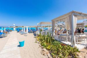 uma praia com cadeiras e mesas e o oceano em Villa Irene em Torre Santa Sabina
