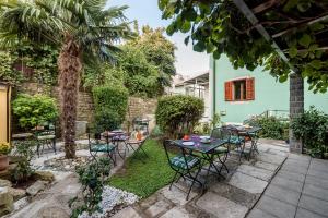 een patio met tafels en stoelen en een palmboom bij B&B Miracolo di Mare Trend in Piran