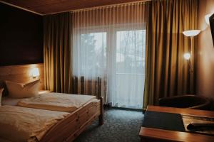 um quarto de hotel com uma cama e uma janela em Gasthof Roseneck em Wallenfels