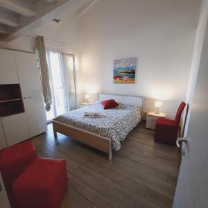 ein Schlafzimmer mit einem Bett und einem roten Stuhl in der Unterkunft Villaggio Esmera in Desenzano del Garda