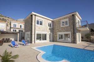a house with a swimming pool in front of it at Luxury Villa Price with private pool near Dubrovnik in Ivanica