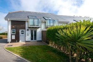 ein weißes Haus mit einem Zaun und Büschen in der Unterkunft Bay Retreat Villas in Padstow