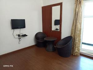 a room with two wicker stools and a television at Apple Breeze Resort in Kotagiri
