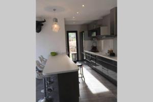 a kitchen with black cabinets and a white counter top at Villa luxe bord de mer avec piscine et grand jardin in Corbara