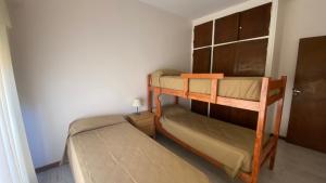 Departamentos Premium Miramar في ميرامار: غرفة نوم بها سريرين بطابقين في الغرفة