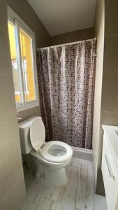 Departamentos Premium Miramar في ميرامار: حمام مع مرحاض وستارة دش