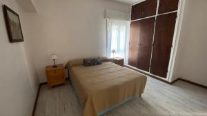 Departamentos Premium Miramar في ميرامار: غرفة نوم صغيرة بها سرير ونافذة +صورة واحدة