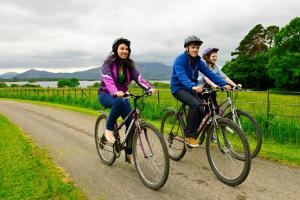 a group of three people riding bikes down a road at The Reserve at Muckross Park in Killarney