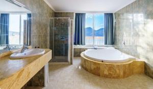Villa Camp de Mar, Sea View في كامب دي مار: حمام مع حوض استحمام ودش ومغسلة