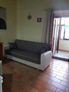 un sofá sentado en una sala de estar junto a una puerta en Appartamento via della Posterna Spoletium, en Spoleto