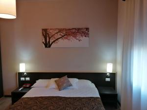 a bedroom with a bed with a tree on the wall at Hotel Eden in Vignola