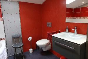 ein rotes Badezimmer mit WC und Waschbecken in der Unterkunft Gîte 4 étoiles avec hébergement insolite - 10 personnes in Foussais
